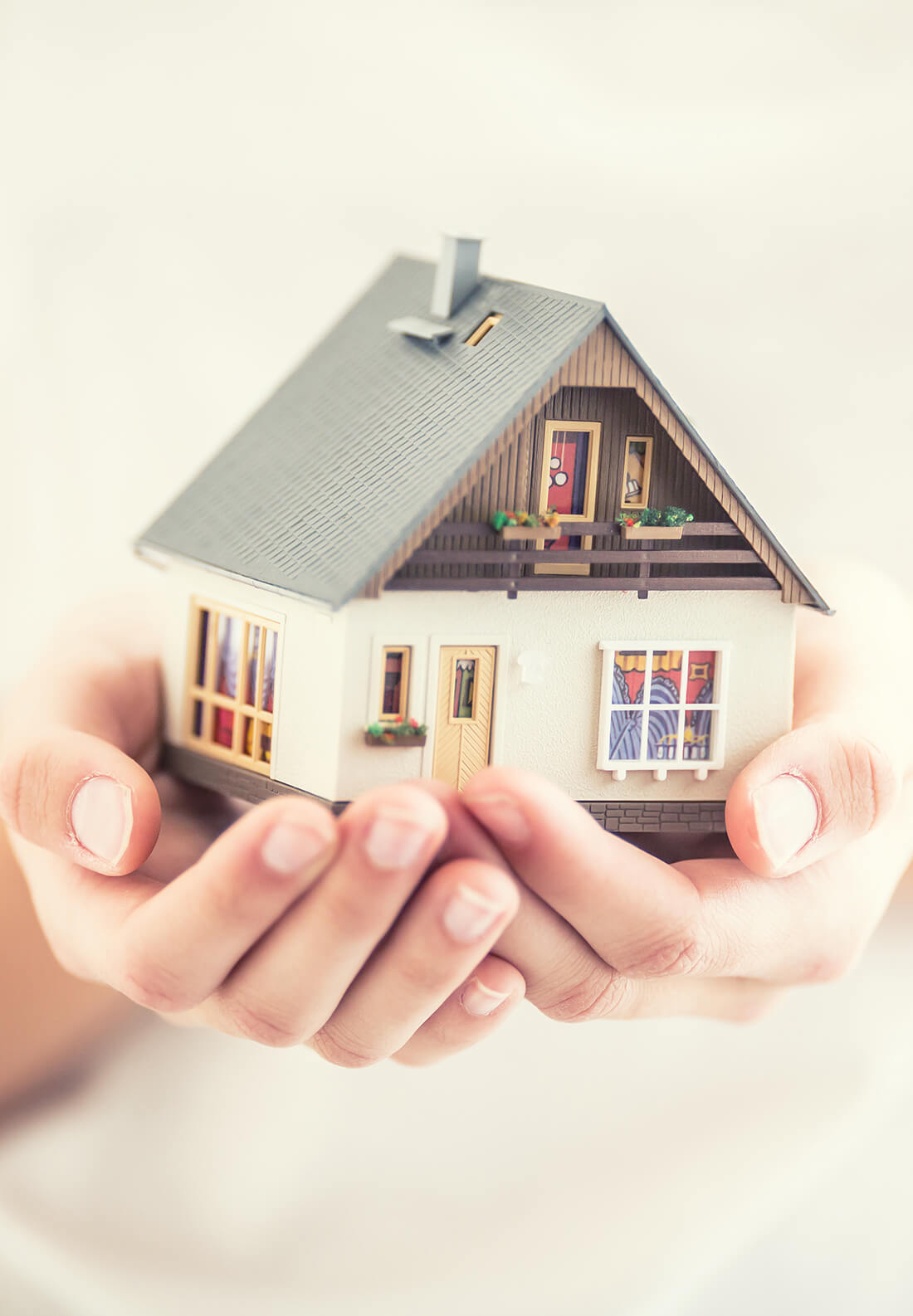 Hands Of Young Woman Holding Model House